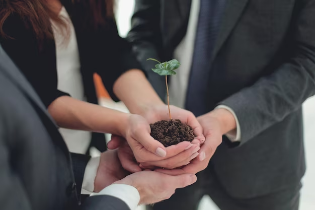Individuals in business attire holding a plant