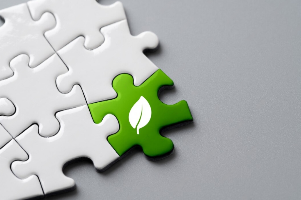 Recycle icon on the white and green puzzle on gray background